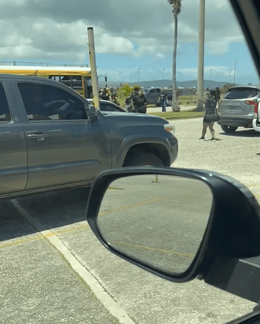 TRAFFIC: Tiyan High School employee seen directing students off a bus at the George Washington High School campus on Wednesday.